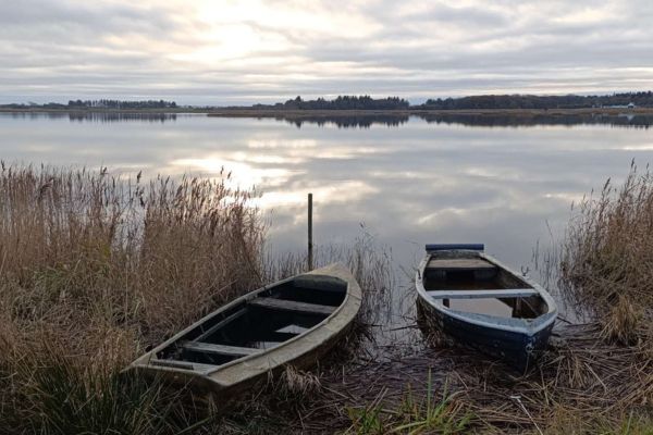 Zwei Boote am Ufer eines Sees. Das Bild steht für die Idee, im Alltag kurz anzulegen und durchzuatmen.