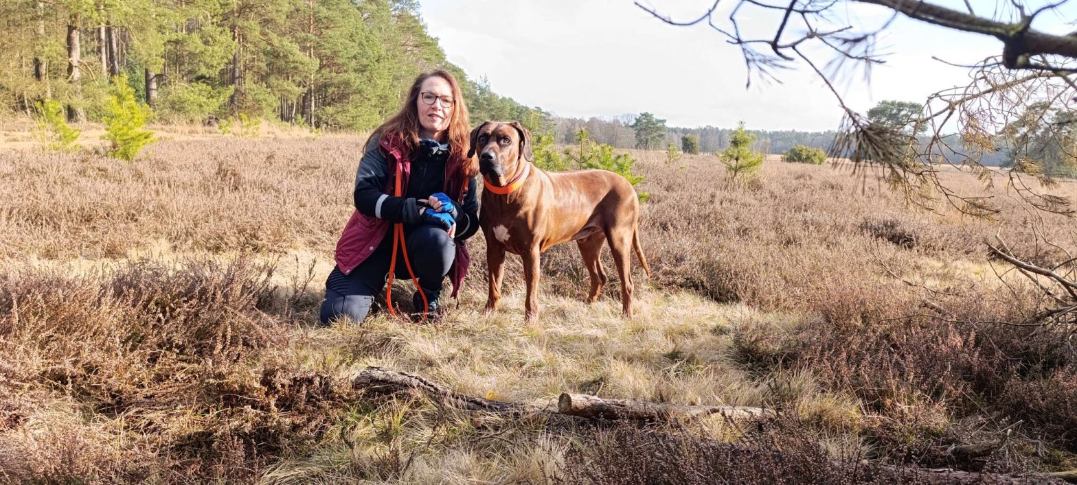 Katja mit ihrem Rhodesian Ridgeback Floyd auf einem Spaziergang durch die blühende Lüneburger Heide.