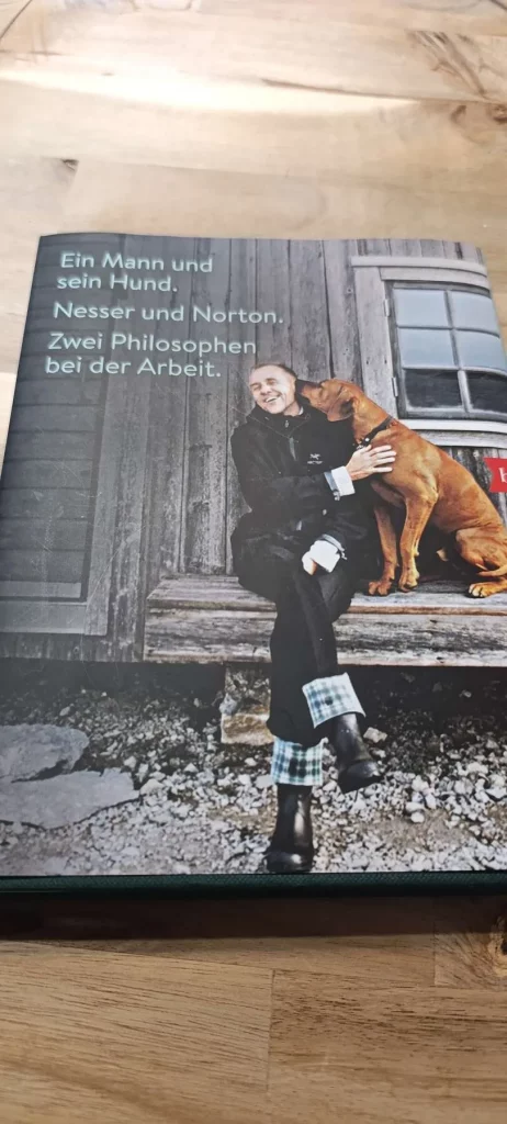 Rückseite des Buchs „Nortons philosophische Memoiren" mit Foto von Håkan Nesser und seinem Ridgeback Norton und dem Text „Ein Mann und sein Hund. Nesser und Norton. Zwei Philosophen bei der Arbeit."